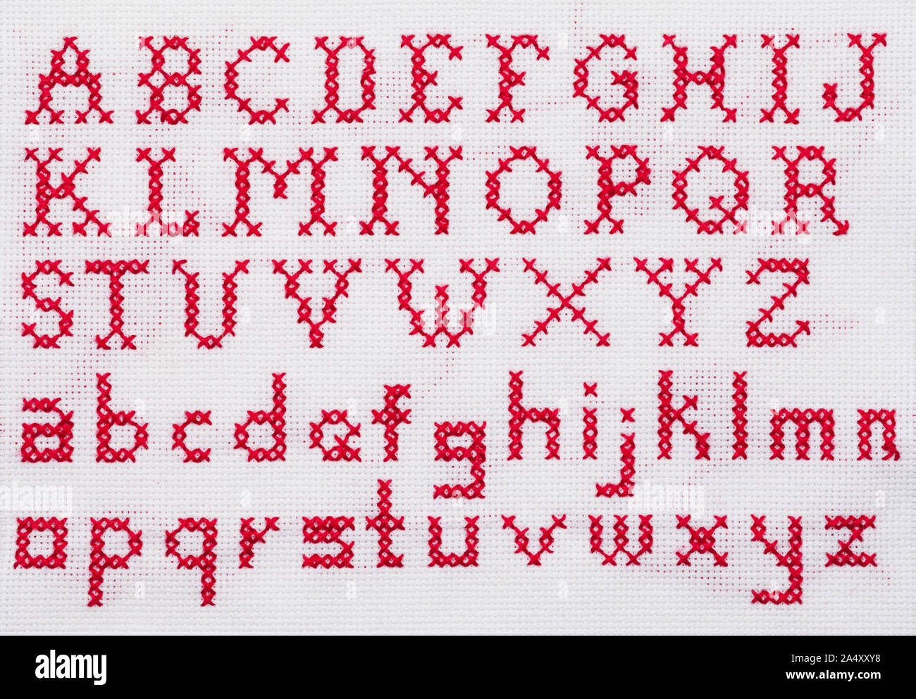Red Alphabet Cross Stitch Sampler mit Groß- und Kleinbuchstaben. Stockfoto
