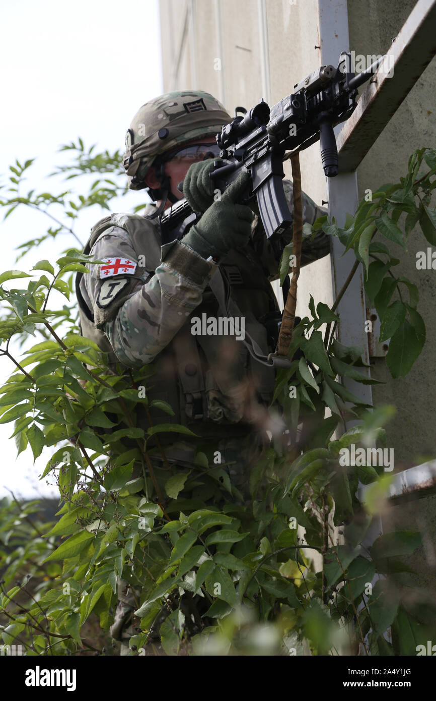 Ein georgischer Soldat mit dem 12 Georgische Infanteriebataillon liefert Sicherheit während des Georgischen Mission Rehearsal Übung am Hohenfels Training Bereich in Deutschland, Okt. 11, 2019. Die georgischen Mission Rehearsal Übung führte durch das US Marine Corps umfasst fast 900 georgische Soldaten und Marines. Die Übung läuft vom 1. Oktober bis Okt. 20 am Joint Multinational Readiness Center in Hohenfels, Deutschland. Die Übung ist darauf ausgerichtet die 12 georgischen Infanterie Bataillon für offensive und defensive Operationen vorzubereiten, und einen Einsatz zur Unterstützung der Operation entschieden. (U.S. Armee Foto b Stockfoto