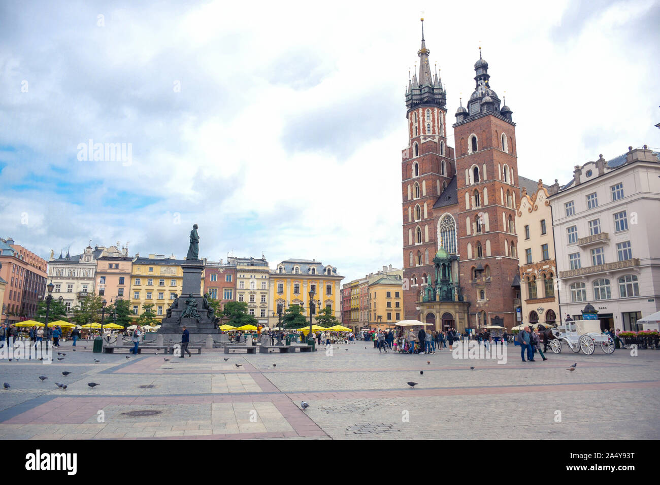 Touristen ihre Zeit genießen Wander- und Spaziermöglichkeiten in der Krakauer Marktplatz mit der Adam-mickiewicz-Denkmal und die Basilika St. Maria in Polen Stockfoto