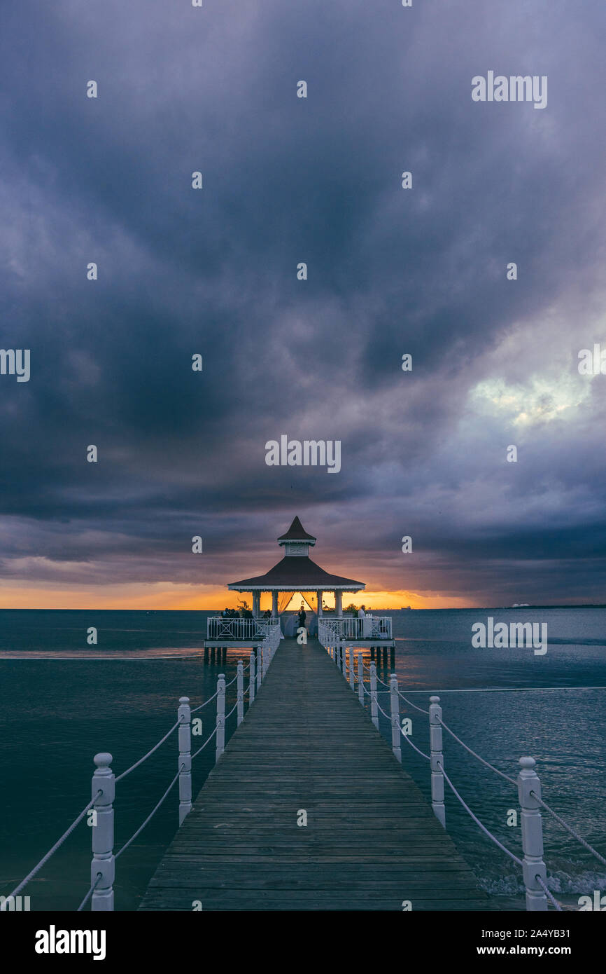 Pavillon mit einem Sonnenuntergang mit Wolken am Strand Stockfoto