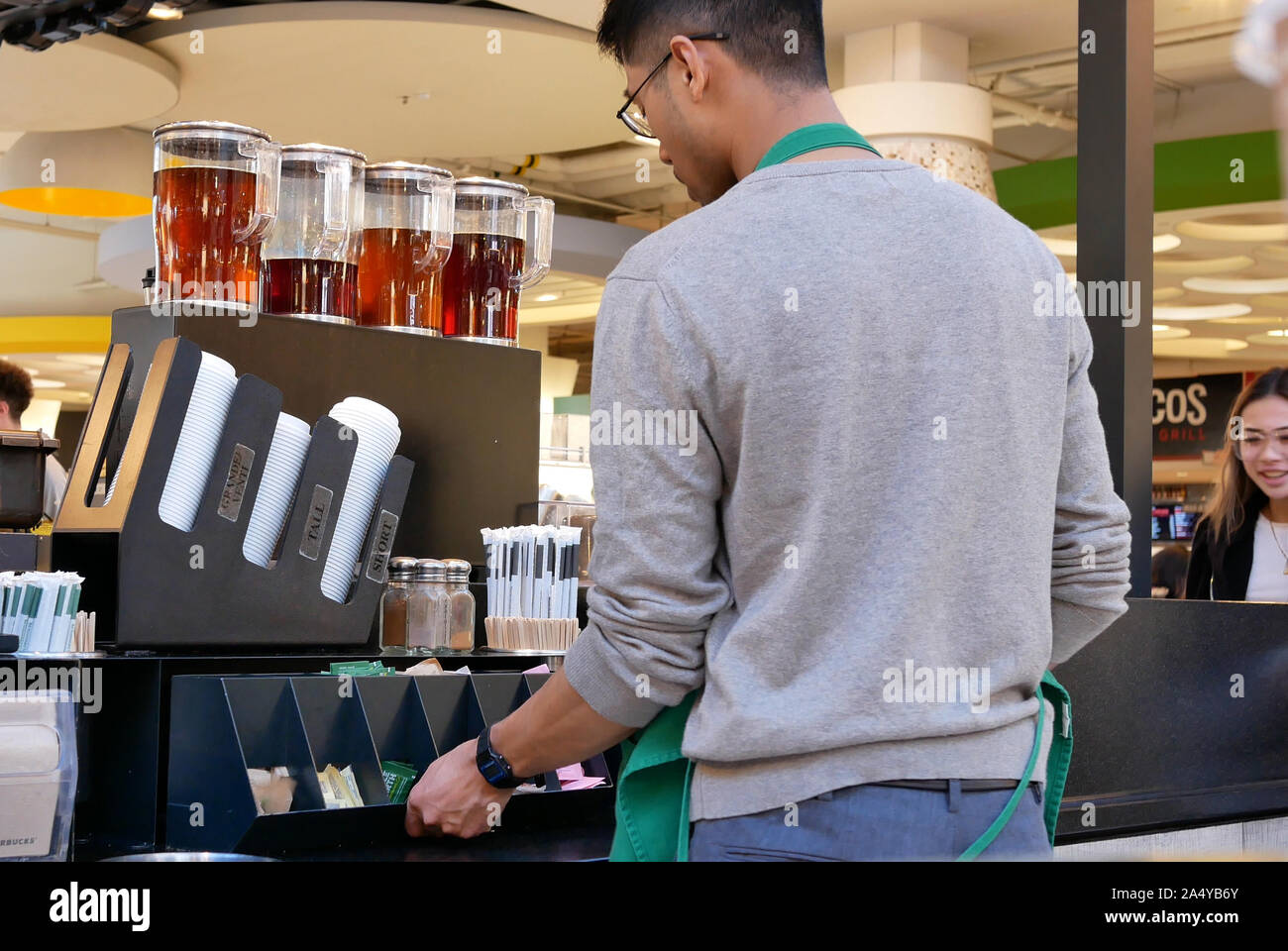 Bewegung der Arbeiter Füllung Zucker auf den Tisch bei Starbucks Store Stockfoto