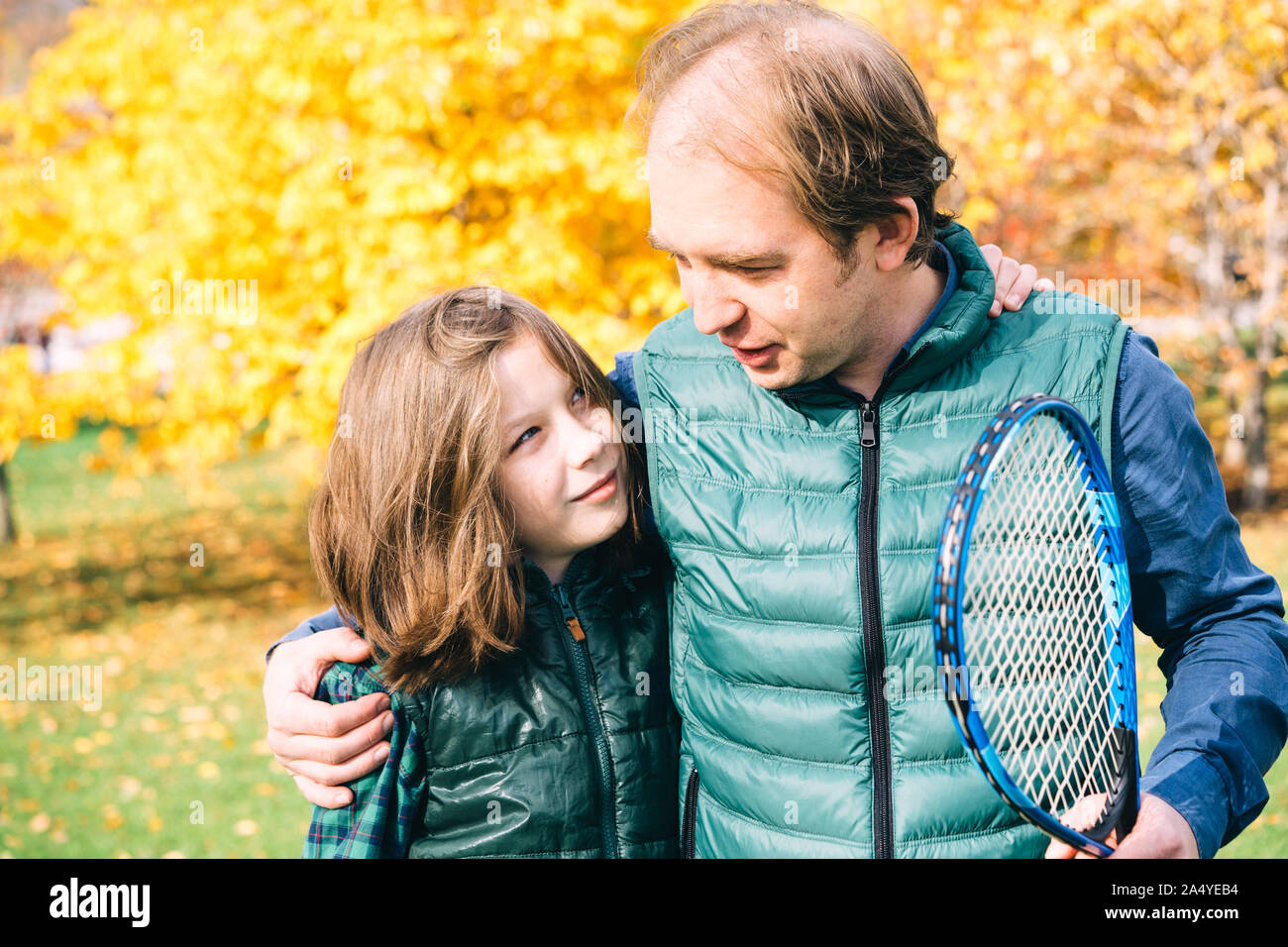 Vater und Sohn im schulpflichtigen Alter sprechen mit Badminton Schläger Stockfoto