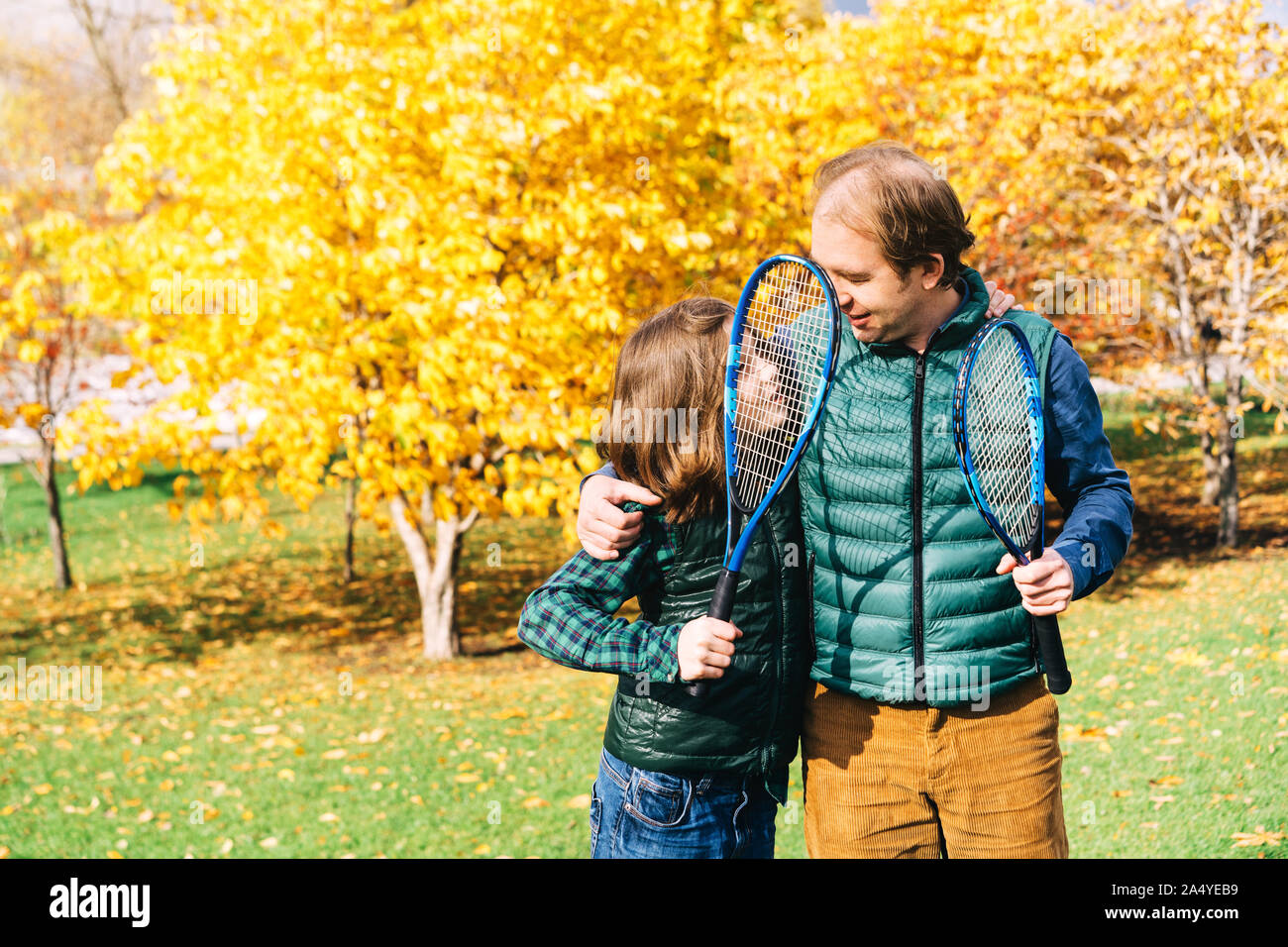 Vater und Sohn im schulpflichtigen Alter sprechen mit Badminton Schläger Stockfoto