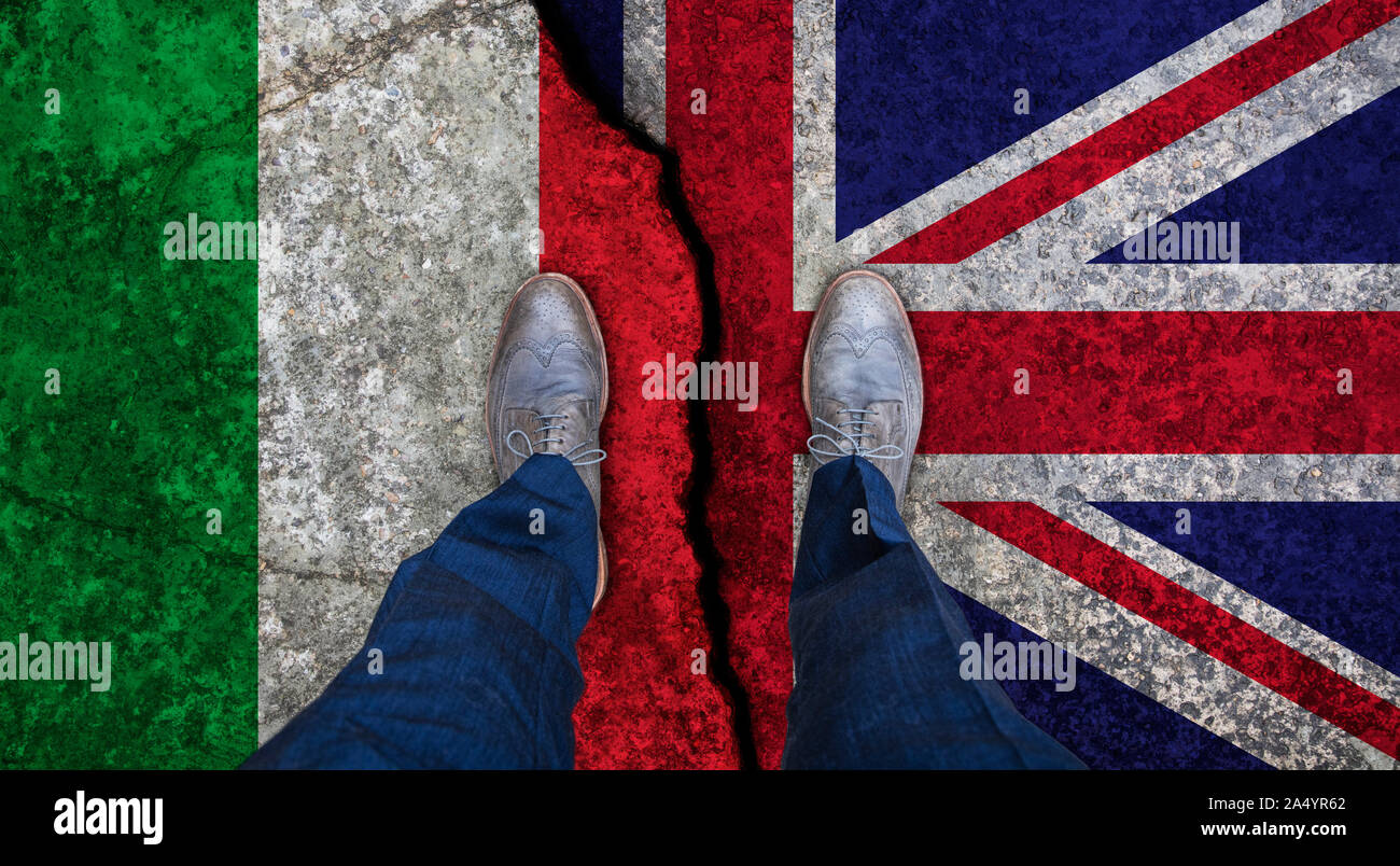 Der Mann steht auf Risse Flagge von Großbritannien und Italien. Politisches Konzept Stockfoto