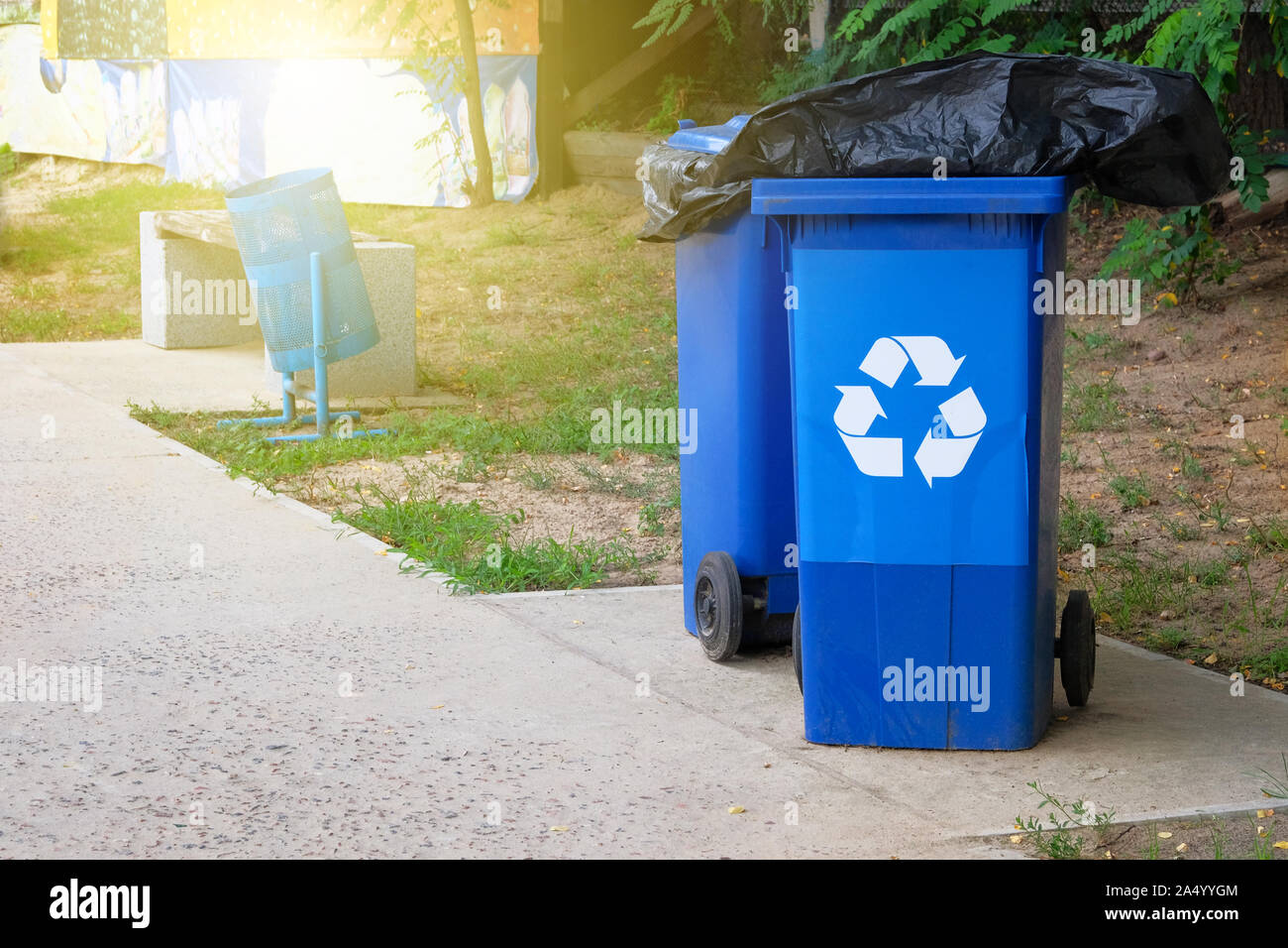 Den blauen Container für die weitere Verarbeitung von Müll. Garbage Collection. Recycling von Abfällen Konzept. Sonnenlicht. Stockfoto