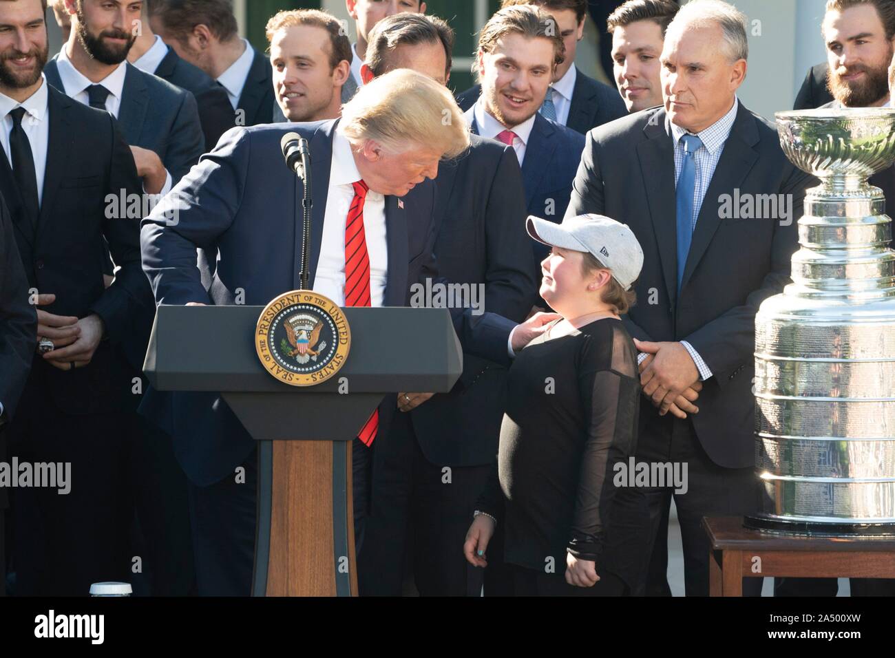 Us-Präsident Donald Trump, Zentrum, umfasst der St. Louis Blues super Fan Laila Anderson, während einer Zeremonie, begrüßte die 2019 Stanley Cup professional Ice Hockey Team, die St. Louis Blues, im Rosengarten des Weißen Hauses Oktober 15, 2019 in Washington, DC. Stockfoto