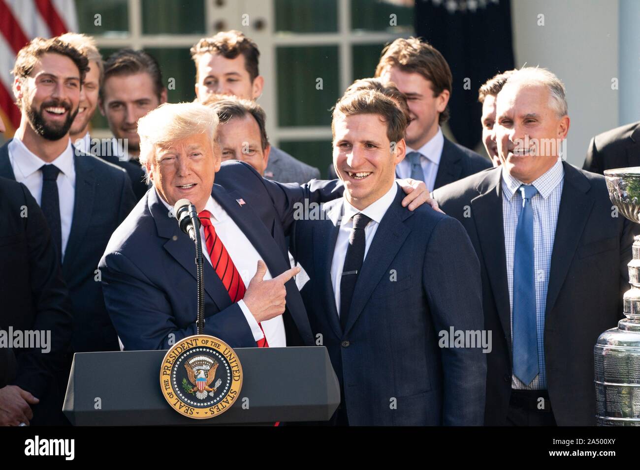 Us-Präsident Donald Trump, Links, umarmt St. Louis Blues player Alex Steen, während einer Zeremonie, begrüßte die 2019 Stanley Cup professional Ice Hockey Team, die St. Louis Blues, im Rosengarten des Weißen Hauses Oktober 15, 2019 in Washington, DC. Stockfoto