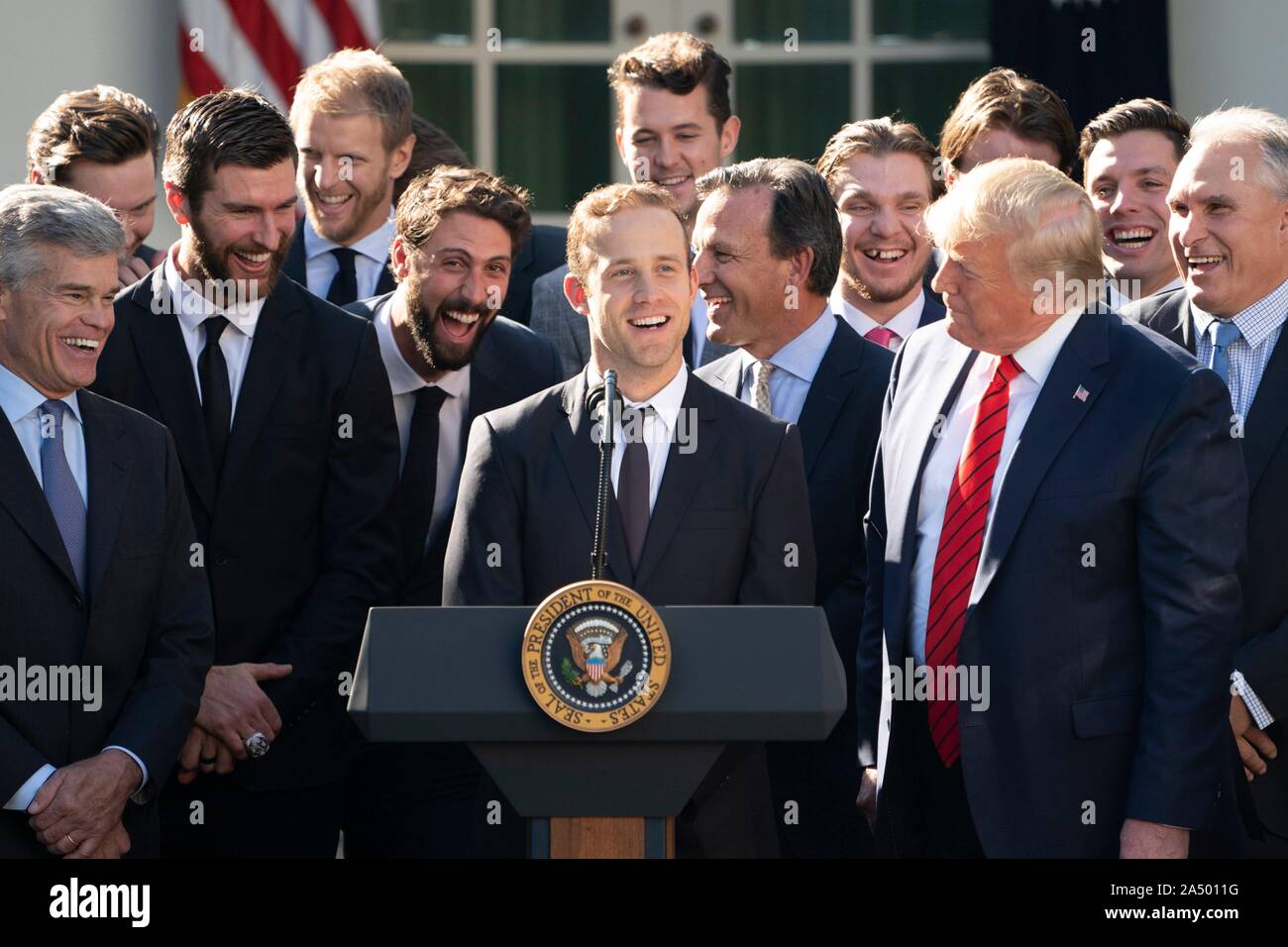 Us-Präsident Donald Trump, rechts, schaut auf die St. Louis Blues player Jaden Schwartz liefert Erläuterungen im Rahmen einer Feierstunde begrüßte die 2019 Stanley Cup professional Ice Hockey Team, die St. Louis Blues, im Rosengarten des Weißen Hauses Oktober 15, 2019 in Washington, DC. Stockfoto