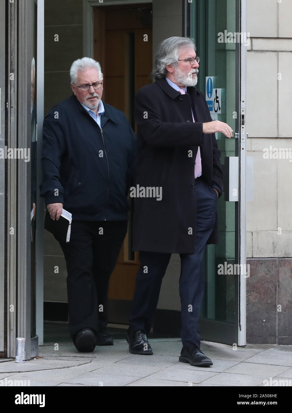 Zuvor noch nicht emittierte Bild vom 14/10/2019 des ehemaligen Sinn Féin Präsident Gerry Adams (rechts), und drücken Sie handler Richard McAuley, verlassen Belfast Crown Court, nachdem er als Zeuge in einem Prozess der Fakten in zwei Aufladungen der Motivierung zur Ermordung von Jean McConville gegen Veteran republikanischen Ivor Bell. Stockfoto