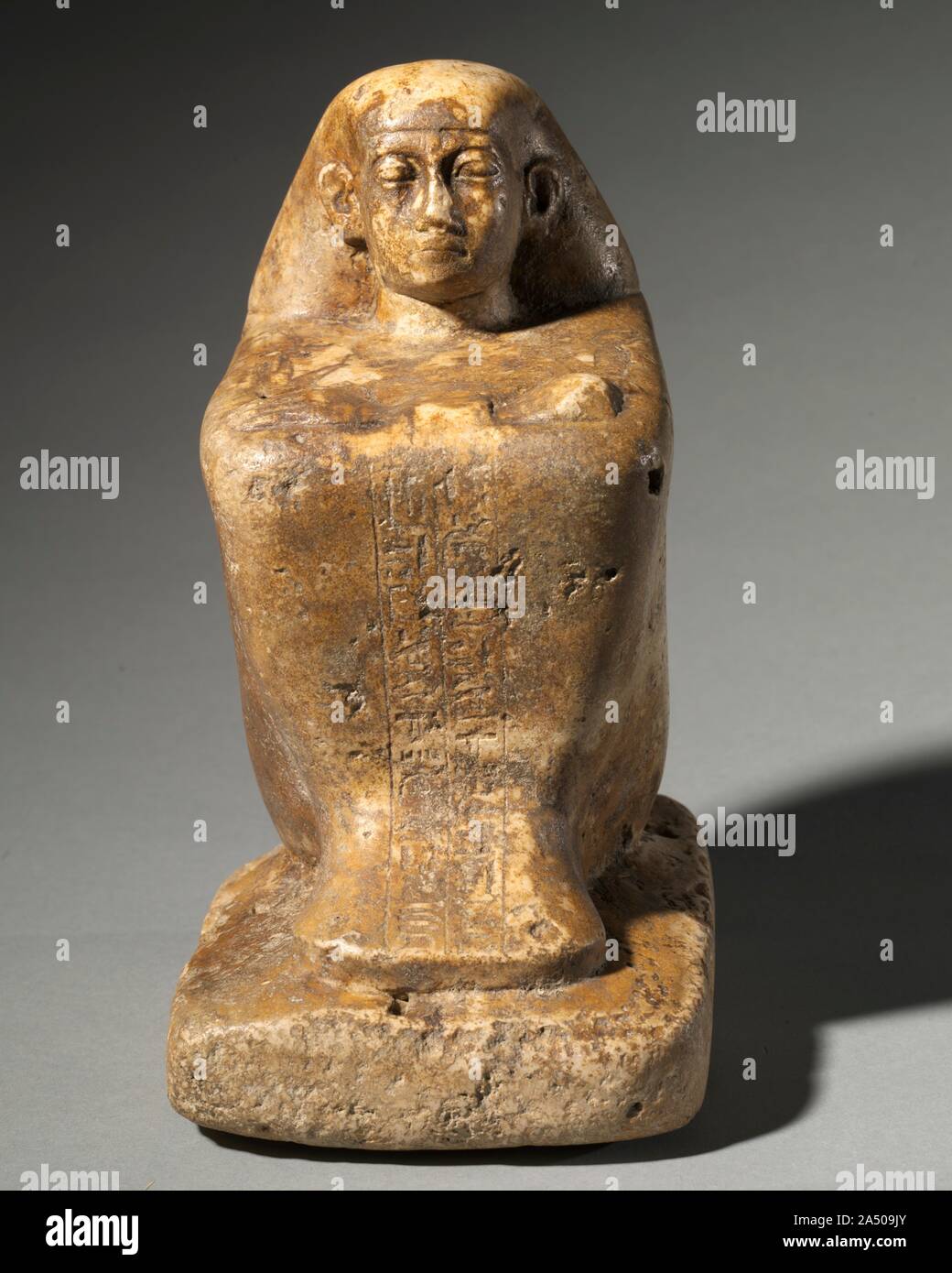 Statue von Djedbastetiufankh, C. 664-610 BC. Es gibt zwei grundlegende Arten von ägyptischen Statuen: Grab Statuen und Tempel Statuen. Die Büste von Ankh-Hor und die Statue von Djedbastetiufankh sind in diesem Fall Tempel Statuen. Die kompakte Form der Statue appellierte an die Ägyptische Bildhauer, weil es nahezu unzerbrechlich ist. Es stellt das Thema hocken auf dem Boden, verschränkte die Arme über die Knie. Seine langen, umhüllenden Mantel ist zu seinem Körper Form geformt, so dass er einen Würfel ähnelt. Von der Position der Arme ist es offensichtlich, dass die Büste von Ankh-Hor gehörte ursprünglich zu einem Str Stockfoto