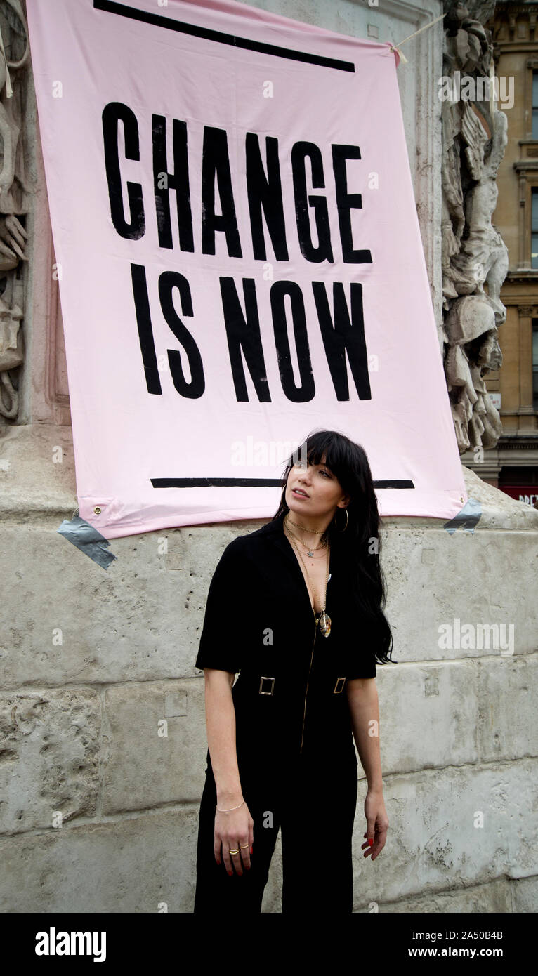 Aussterben Rebellion, Central London, Oktober 7 2019. Trafalgar Square. Modell Daisy Lowe vor einem Banner mit der Aufschrift "Veränderung ist jetzt'. Stockfoto