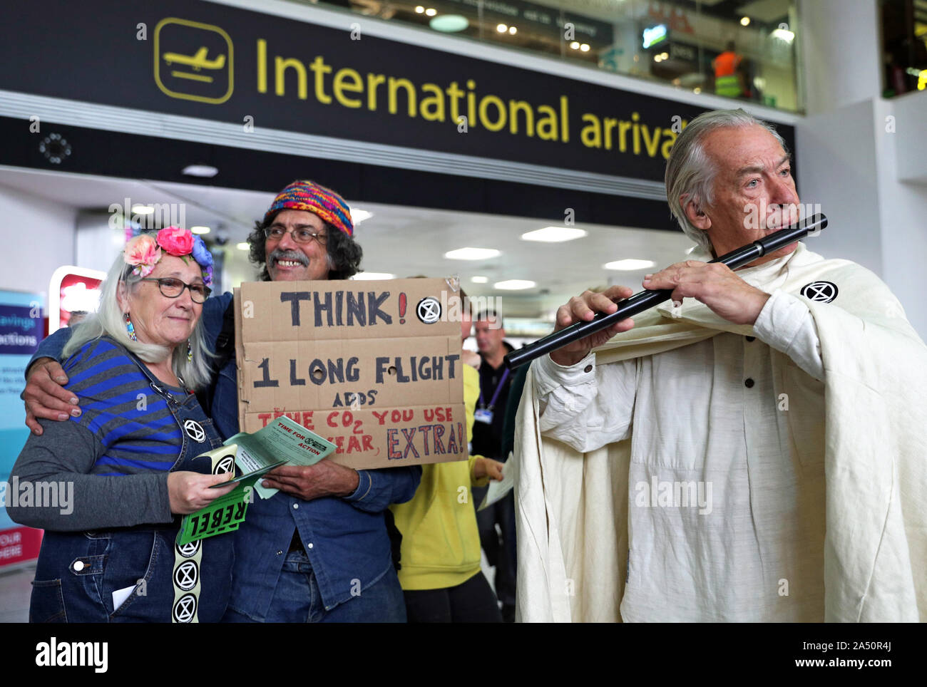 Ein flötist verbindet die Demonstranten in der South Terminal am Flughafen Gatwick bei einem Aussterben Rebellion (XR) Klimawandel protestieren. PA-Foto. Bild Datum: Donnerstag, Oktober 17, 2019. Siehe PA Geschichte Umwelt Proteste. Photo Credit: Andrew Matthews/PA-Kabel Stockfoto