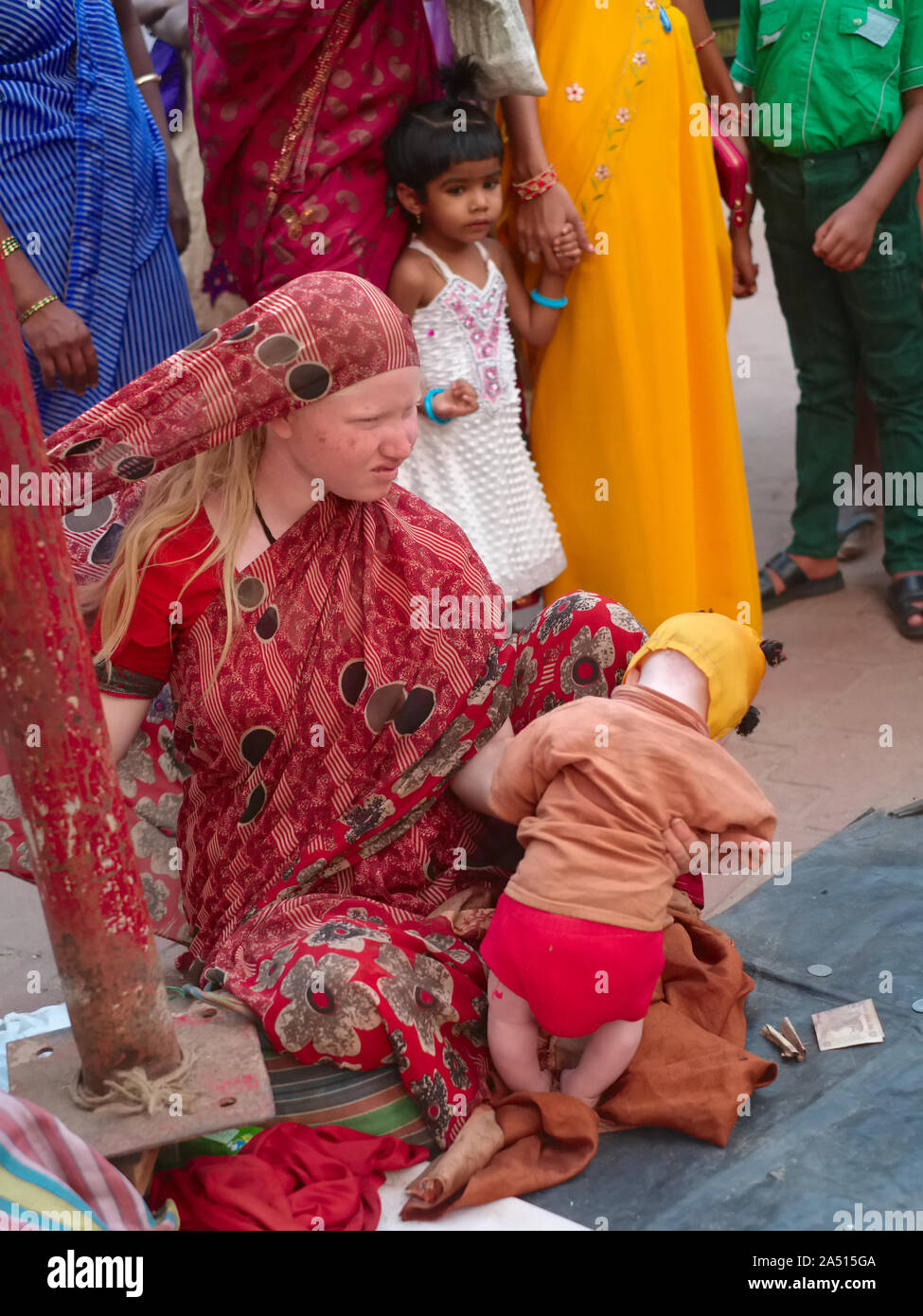 Die Mitglieder des Erweiterten Indischen albino Familie, eine Frau und ihr Kind, um Spenden in Udipi, Karnataka, Indien, durch eine Schar von Einheimischen umgeben Stockfoto