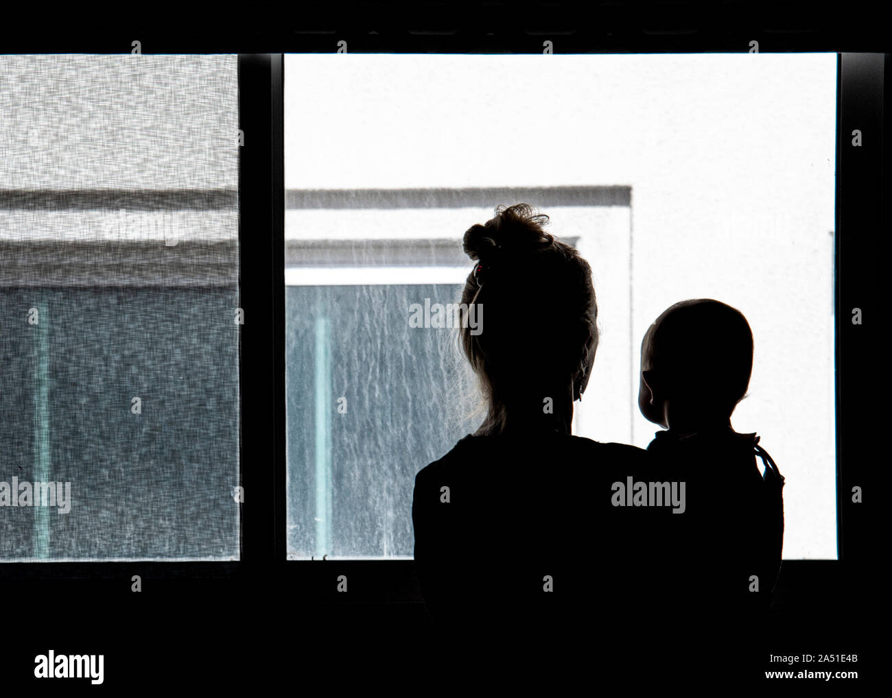 Silhouetten von Frau und Baby, Blick auf eigenschaftslosen, Betonwand Stockfoto