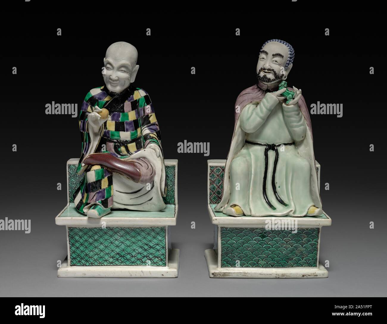 Lohan Holding ein Pfirsich; Lohan Holding ein Fu Hund, 1662-1722. Diese zwei lohans, Schüler des Buddhas mit übernatürlichen Kräften, waren vielleicht Teil eines Hauses Altar oder ein dekoratives Element in einem Haushalt. Lohans, auch als arhats bekannt sind, sind so zu zähmen Tiger in der Lage zu sein und treten auf dem Wasser. Hier sind sie als monklike Zahlen, einer Holding der Pfirsich der Unsterblichkeit, der andere ein f u-Hund dargestellt. Der Lohan mit einem kahlen Kopf trägt einen Mönch ’s Robe aus Patches. Diese beiden Figuren verkörpern eine humorvolle Haltung und spielerische Verhalten, Gleichgültigkeit zu Gefahr und Wunder, und daher eine Loslösung von weltlichen affai Stockfoto