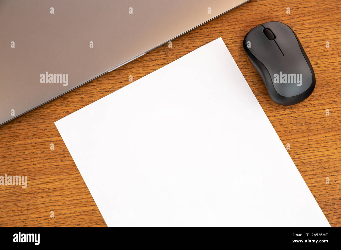 Minimaler Arbeitstisch aus Holz mit leerer Seite, Kopierplatz, Stift, Laptop, Maus. Draufsicht, Textbereich, Modell. Schreibtisch. Stockfoto