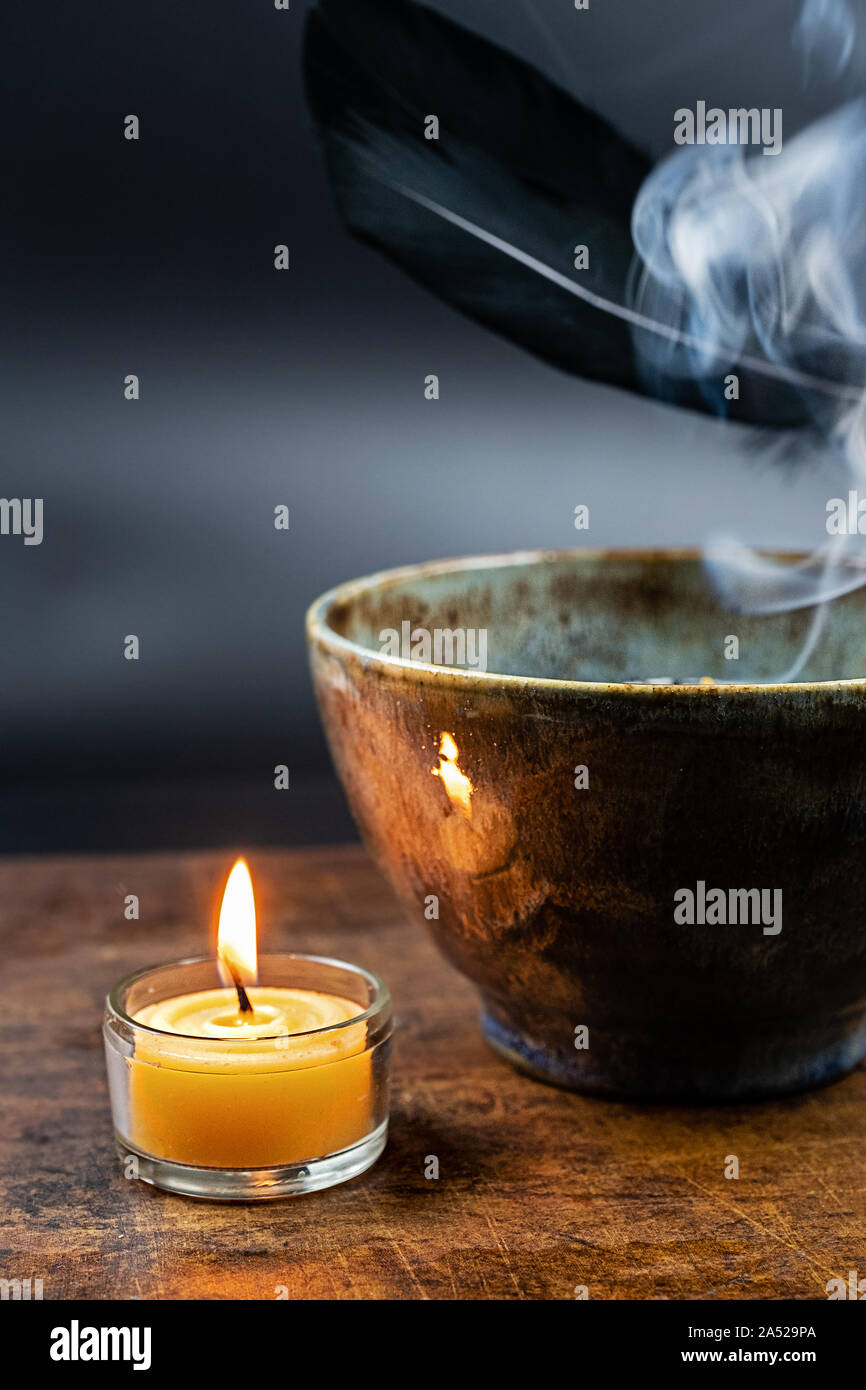 Weihrauch, brennende Kerze aus Bienenwachs und Keramik Schüssel mit Mit glimmenden Kräutern Stockfoto