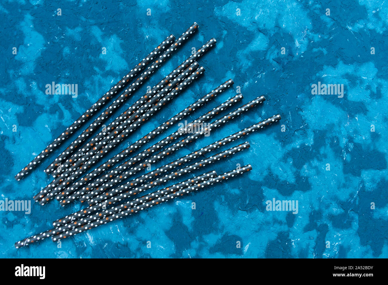 Schwarz cocktail Rohr auf eine strukturelle blauer Hintergrund für eine festliche Getränke, festlichen Hintergrund. Stockfoto