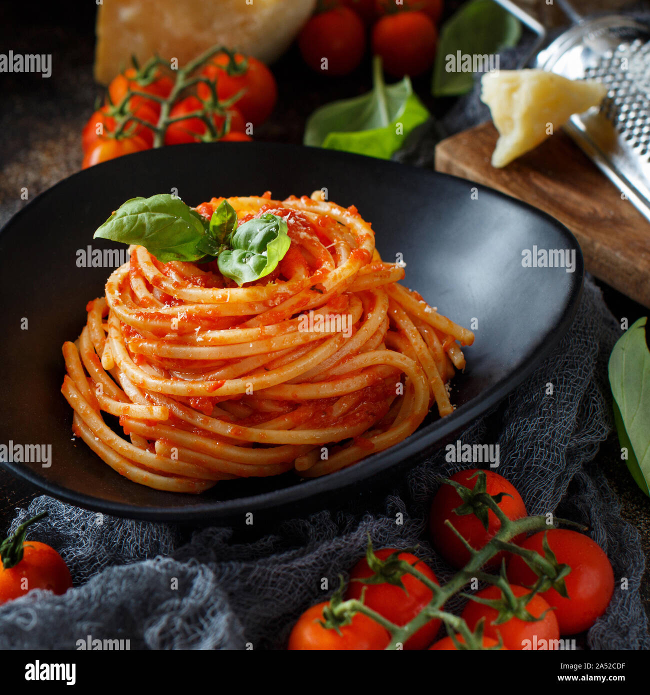 Spaghetti Pasta mit Tomatensauce, Basilikum und Käse auf einem dunklen Tabelle Stockfoto