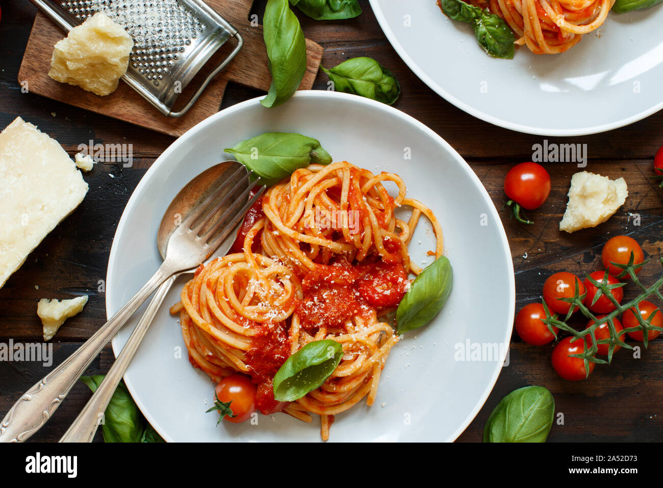 Spaghetti Pasta mit Tomatensauce, Basilikum und Käse auf einem dunklen Tabelle Stockfoto