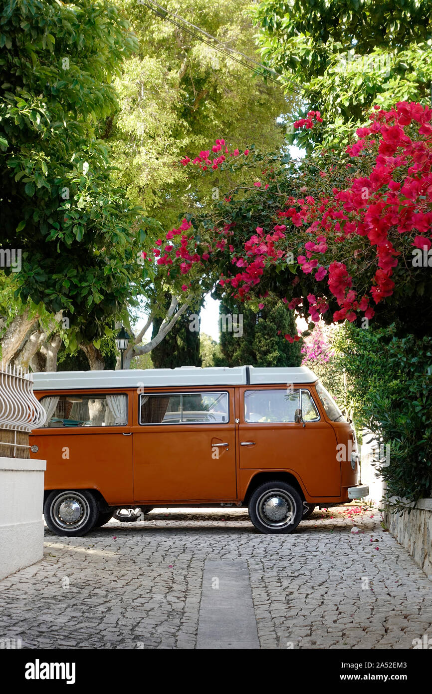 Klassischer VW Campervan Typ 2 der dritten Generation in Orange und weiß geparkt in Einer malerischen Straße Blumen Blüten in Cascais Portugal Stockfoto Stockfoto