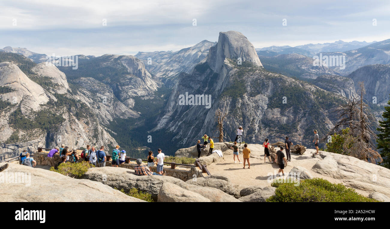 YOSEMITE, USA - 15. SEPTEMBER 2019: Touristen bewundern Sie den Blick auf den Half Dome und das Tal vom Glacier Point in Yosemite National Park. Stockfoto