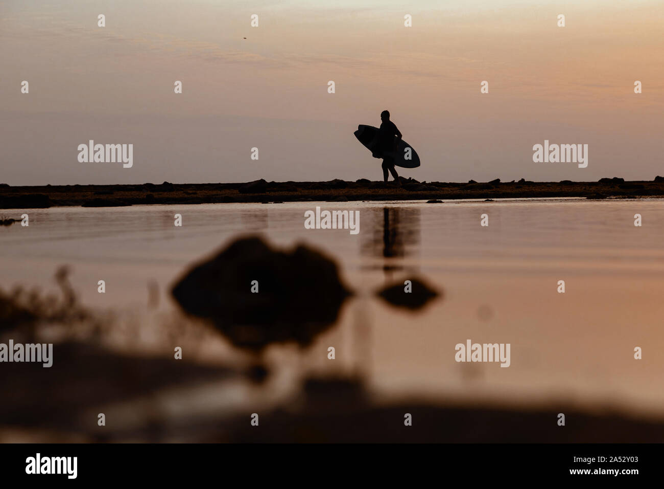 Silhouette der Surfer bei Sonnenuntergang am Strand Stockfoto