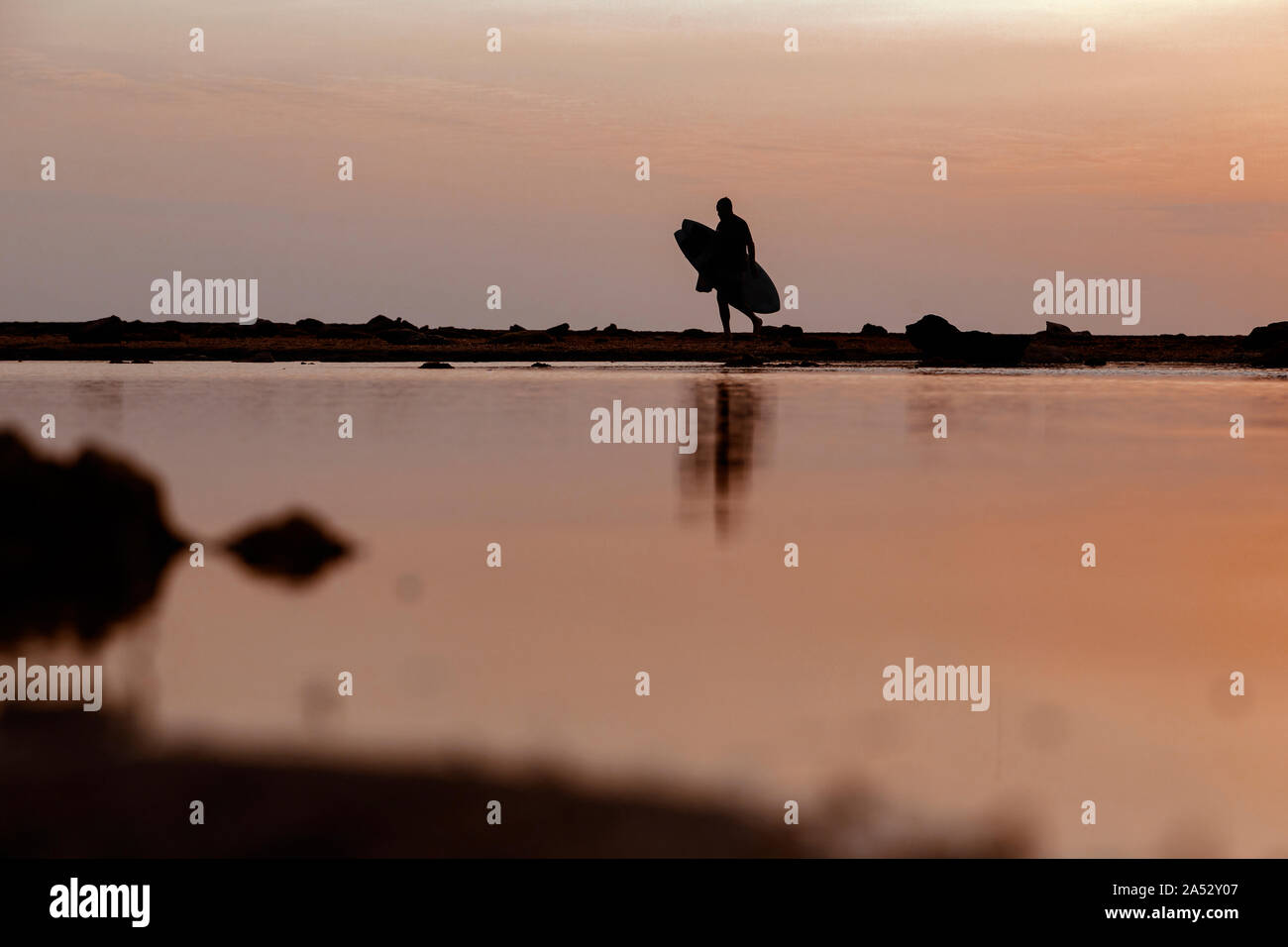 Silhouette der Surfer bei Sonnenuntergang am Strand Stockfoto