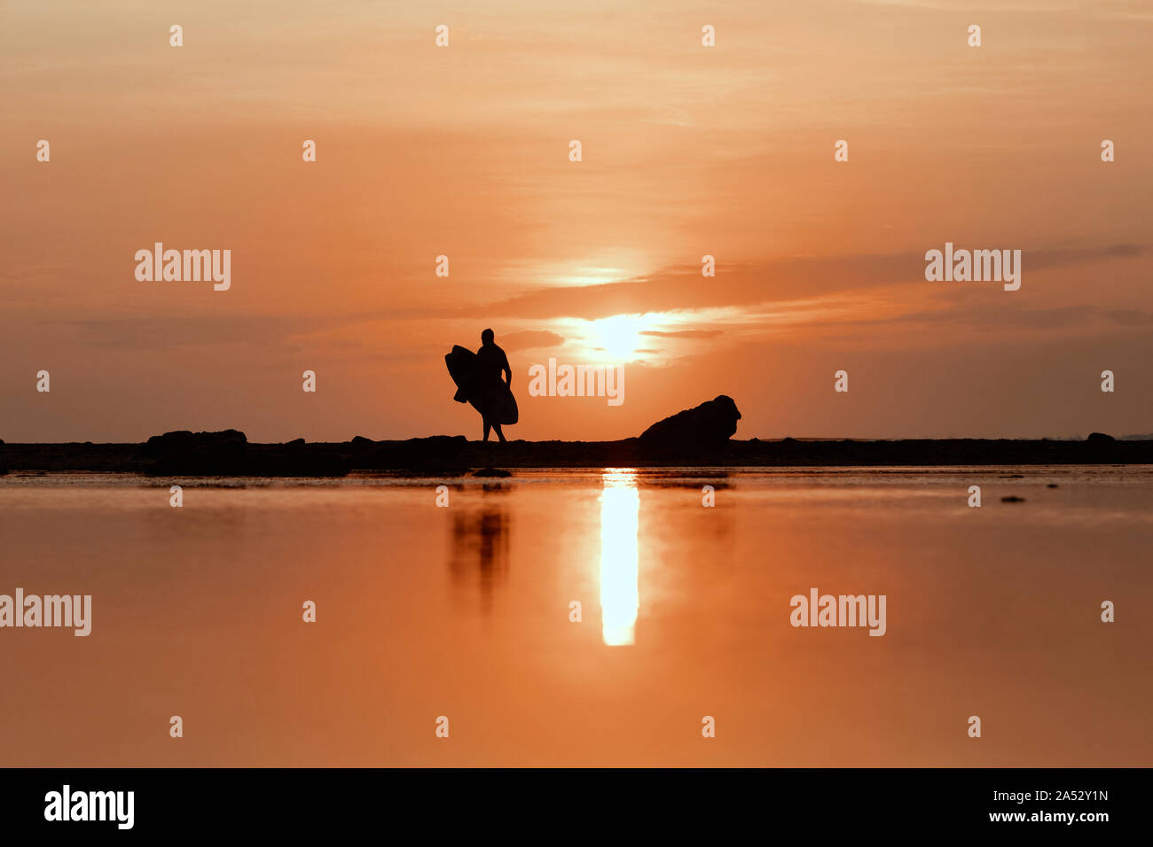 Silhouette der Surfer bei Sonnenuntergang am Strand Stockfoto