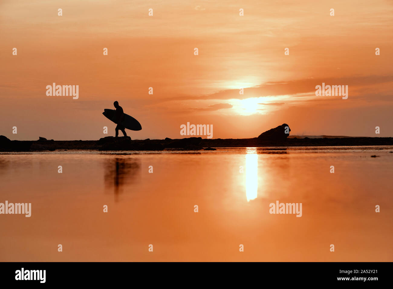 Silhouette der Surfer bei Sonnenuntergang am Strand Stockfoto