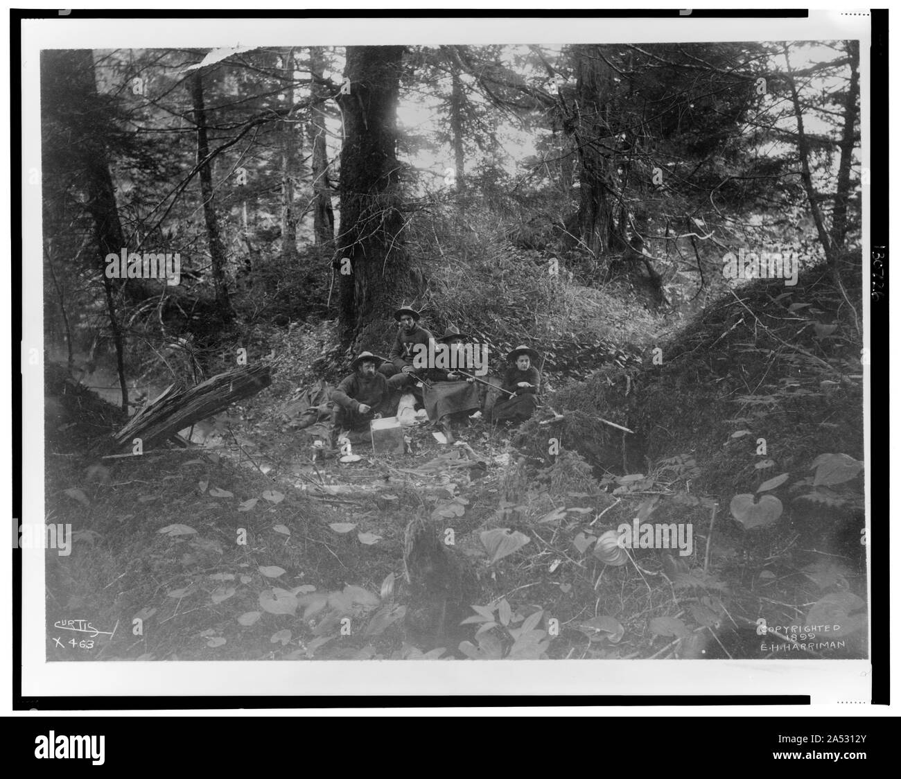 Zwei Männer und zwei Frauen in Wald in Alaska sitzt, 1899] / Curtis Stockfoto