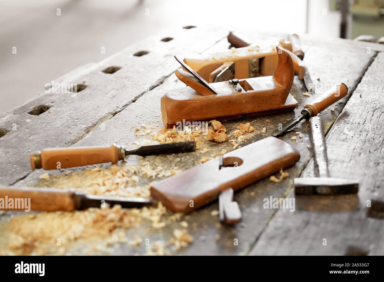 Werkbank mit sortierten Hand Tools in einer Holz- oder Schreinerei inklusive Meißel, Planer und Hammer in der Nähe zu sehen. Stockfoto