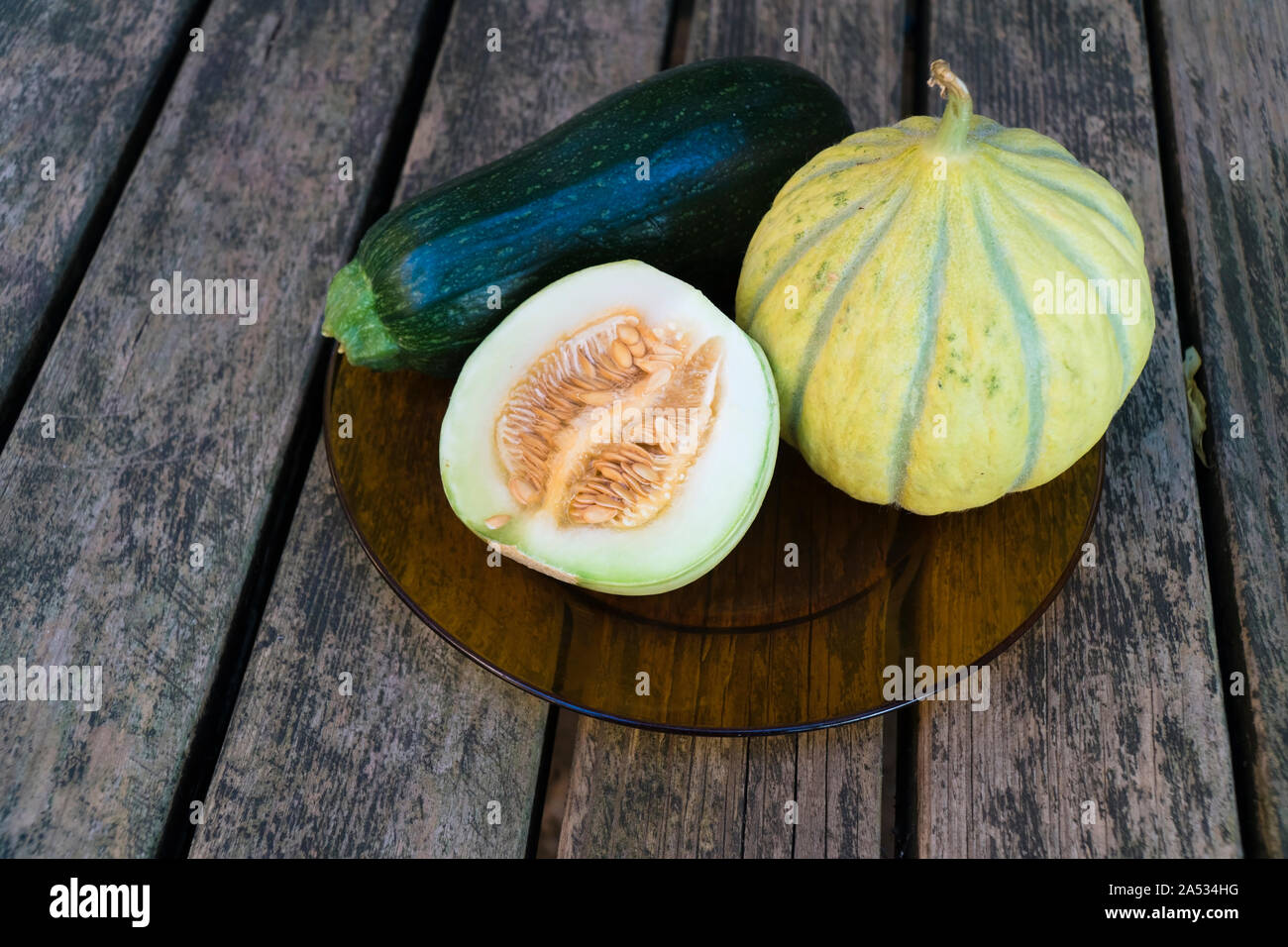 Gentechnikfreie Melonen und Zucchini auf einem Holztisch Stockfoto