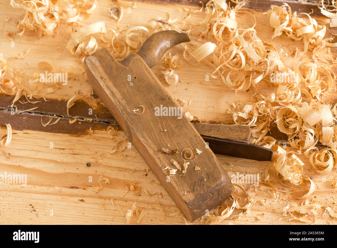 Entsorgt alte hölzerne Hand Ebene für die Holzbearbeitung mit Holzwolle. Stockfoto