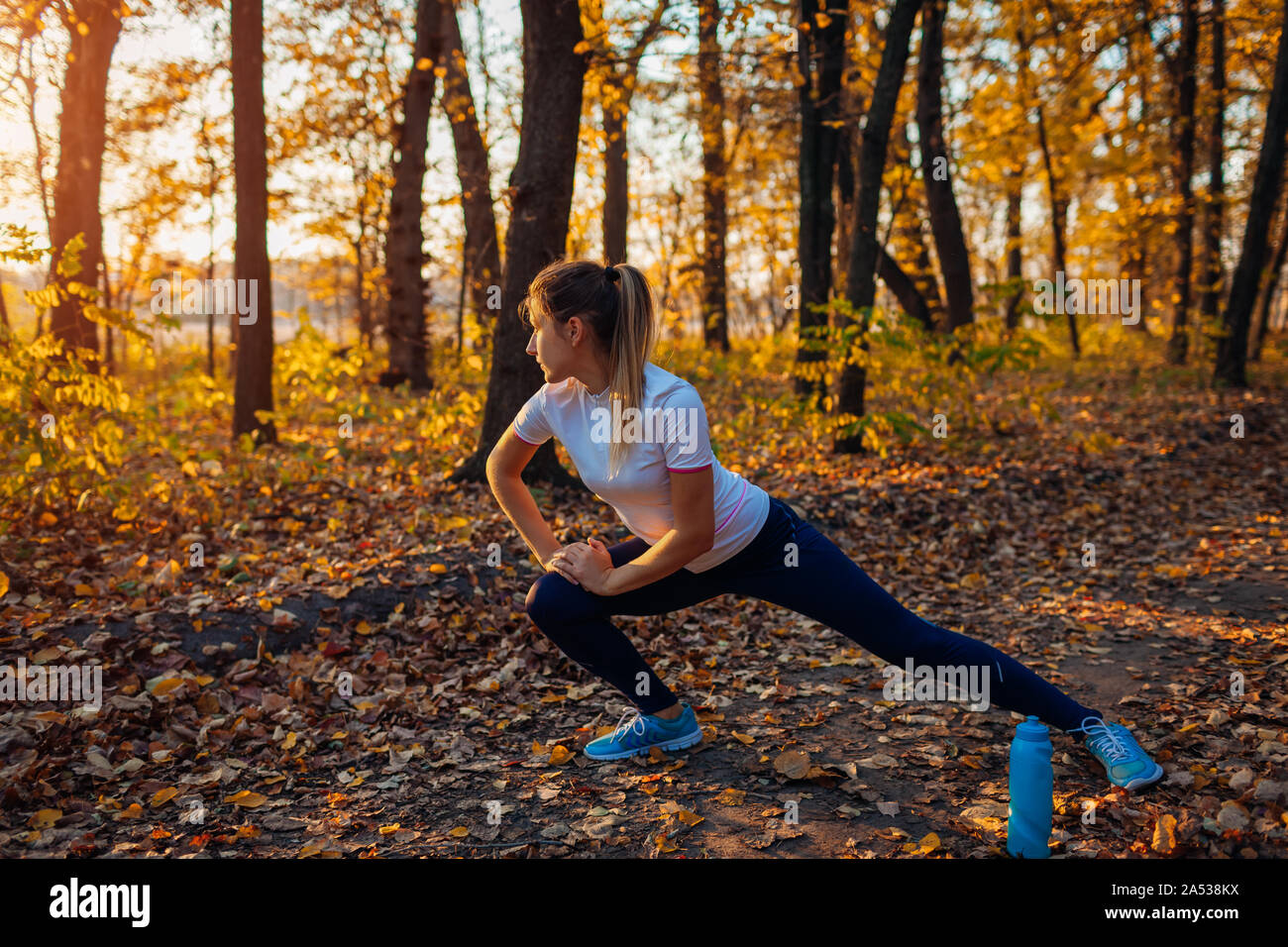 Ausbildung und Training im Herbst Park. Frau stretching Beine im Freien. Aktiv gesund Lifestyle. Aktiv gesund Lifestyle. Training Stockfoto
