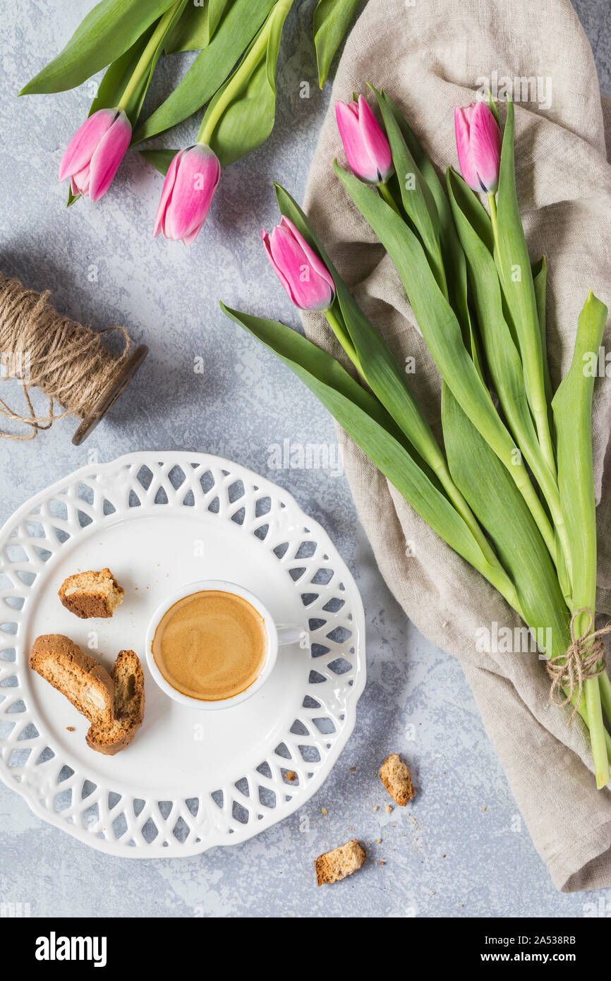 Schöne rosa Tulpen mit einer kleinen Tasse Espresso Kaffee und Biscotti Kekse. Wenn die Ansicht von oben, flach Perspektive. Es gibt auch eine vi Stockfoto