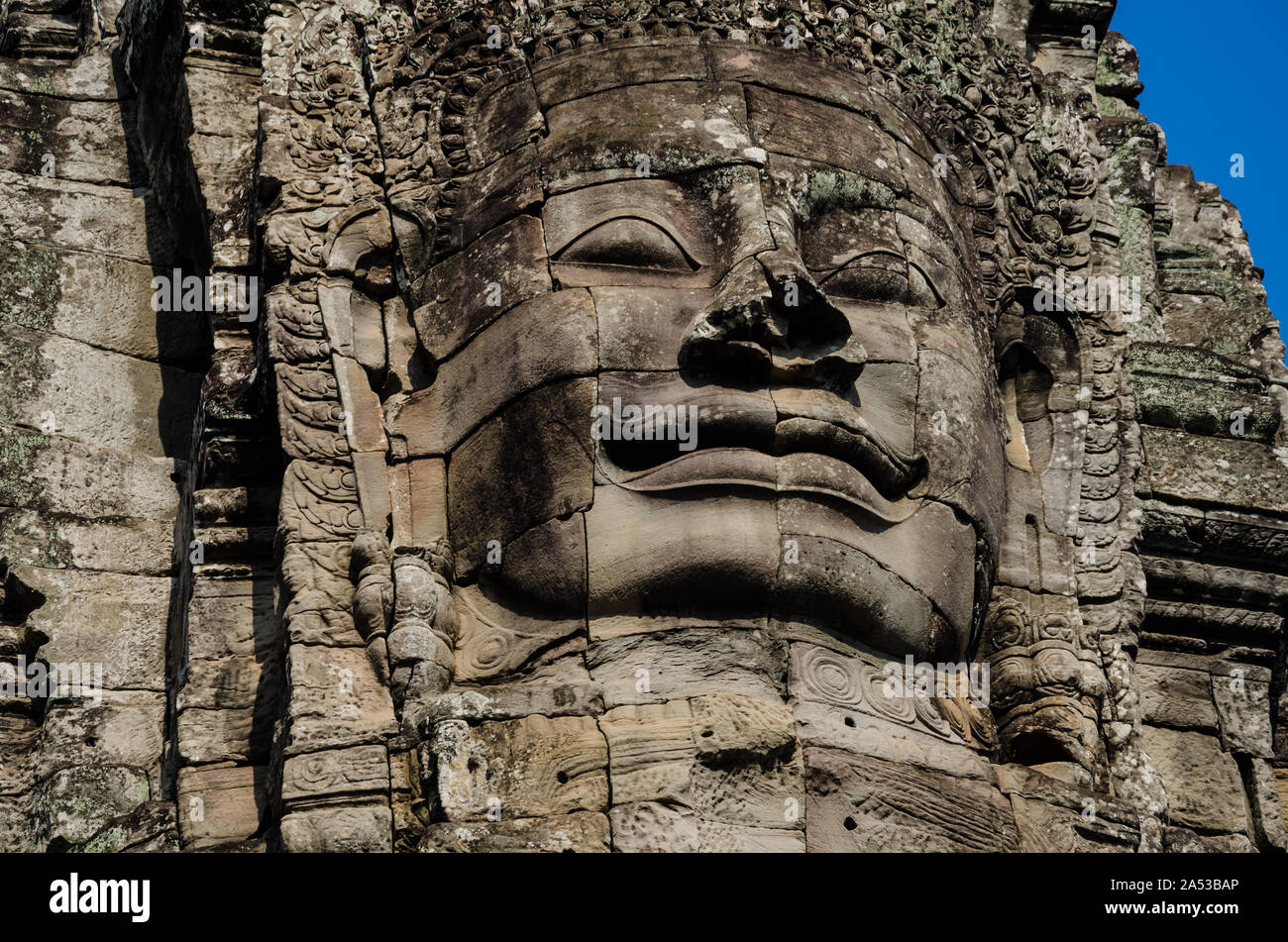 Alte steinerne Gesichter der asiatischen Kultur, in verlassenen Tempeln - Angkor Wat Stockfoto