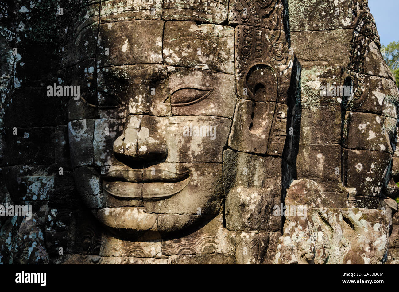 Alte steinerne Gesichter der asiatischen Kultur, in verlassenen Tempeln - Angkor Wat Stockfoto