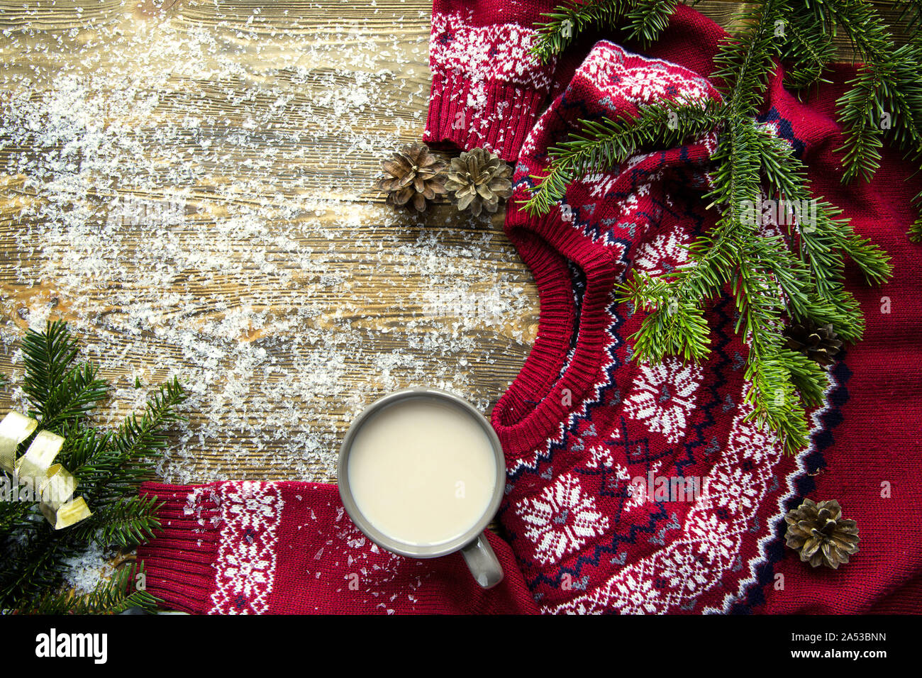 Eine Tasse heißen Kakao auf braunen Tisch. Eine Menge Schnee und rote traditionelle Pullover. Gemütliche magic weihnachtliche Atmosphäre. Platz für Text. Stockfoto