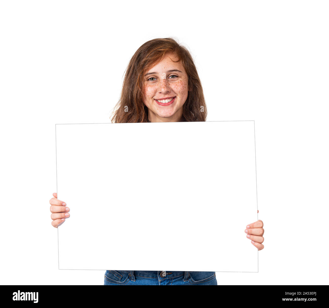 Horizontale studio Shot mit einem lächelnden vor - jugendlich Mädchen mit Sommersprossen Holding ein leeres weißes Schild. Auf weiß isoliert. Stockfoto