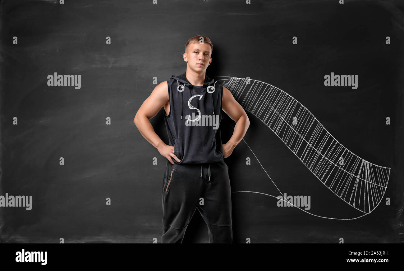 Bemuskelt junger Mann mit gezogenen Cape und Superman Zeichen auf der Brust Stockfoto