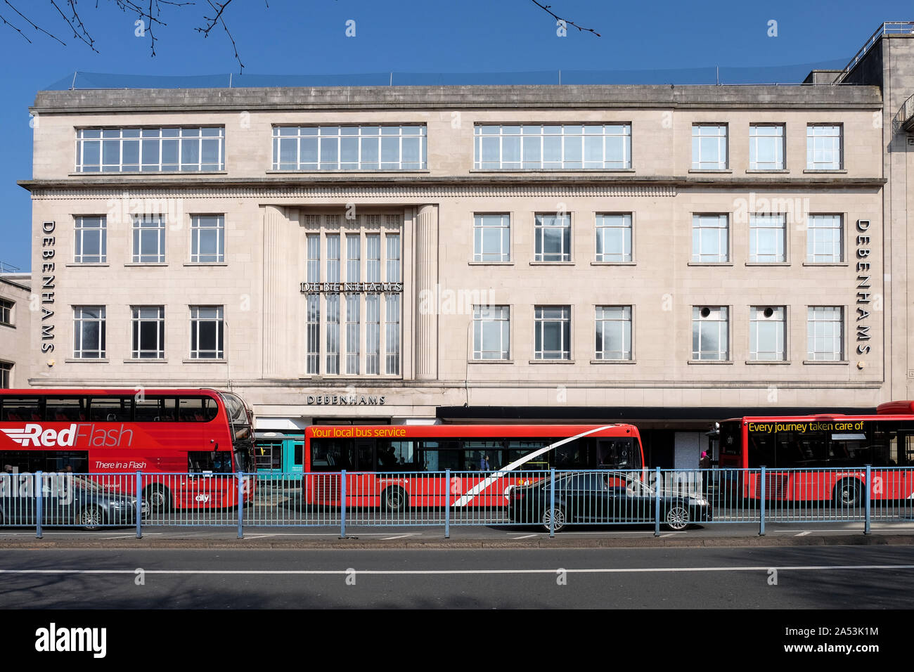 Debenhams Kaufhaus. Moderne Architektur des Stadtzentrums von Plymouth an einem sonnigen Frühlingstag mit roten Bussen. Stockfoto