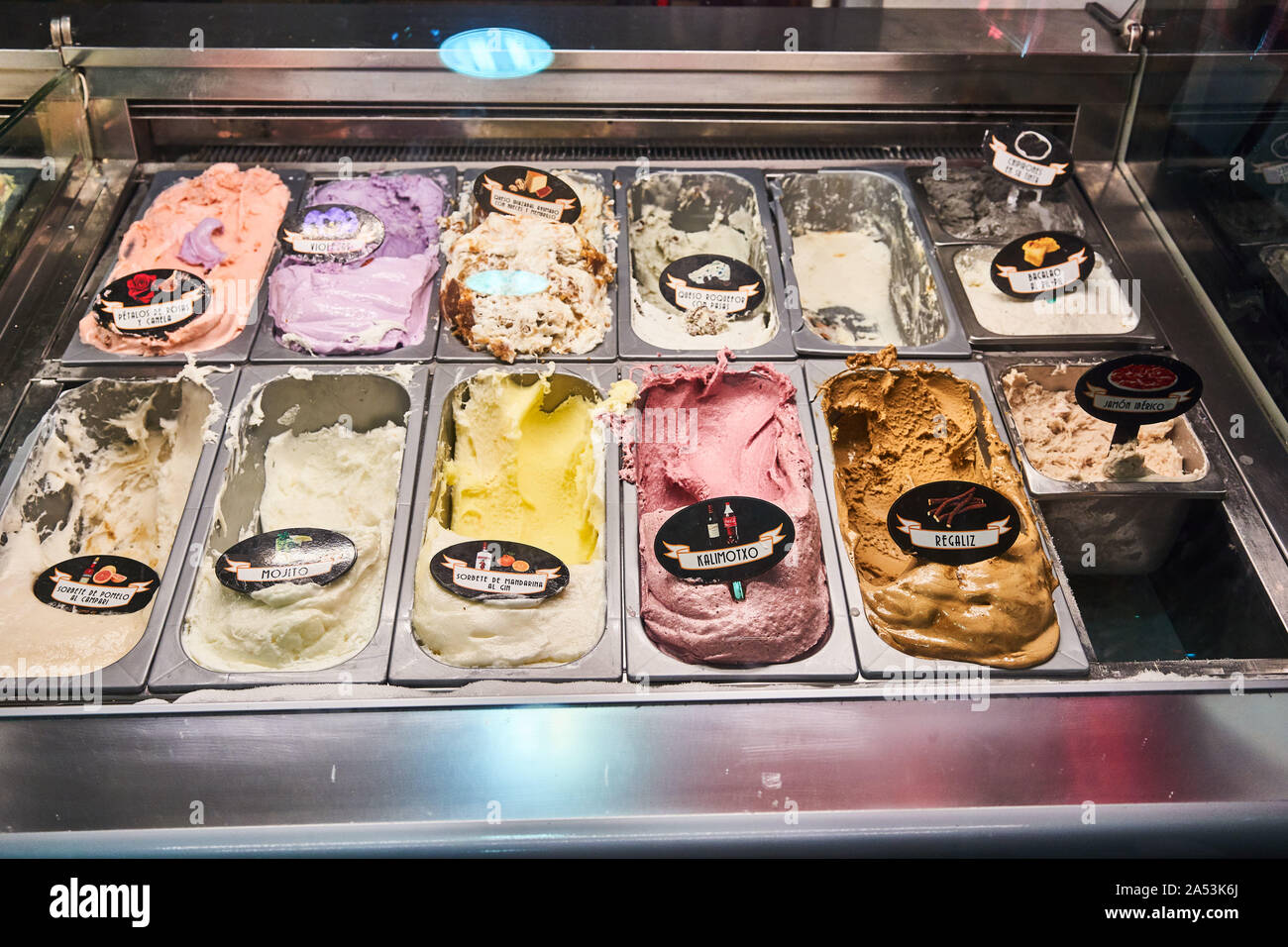 Becher mit bunten Eiscreme-Sorten mit Etiketten in der Auslage der Eisdiele Nossi-Be, Bilbao, Spanien Stockfoto