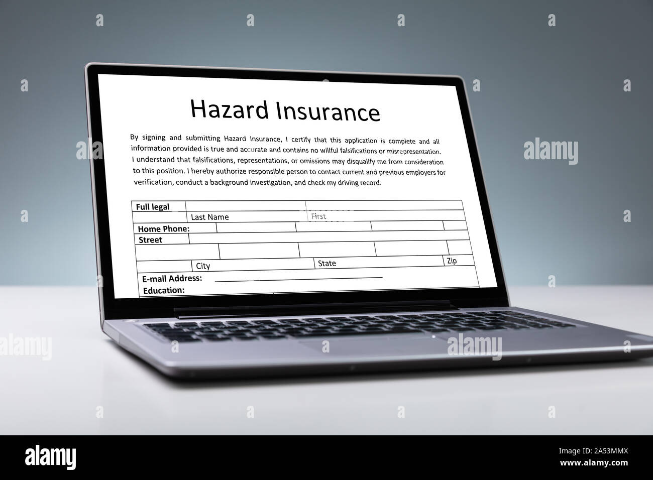 Laptop mit Online Gefahr Versicherung Form auf dem Schreibtisch Stockfoto
