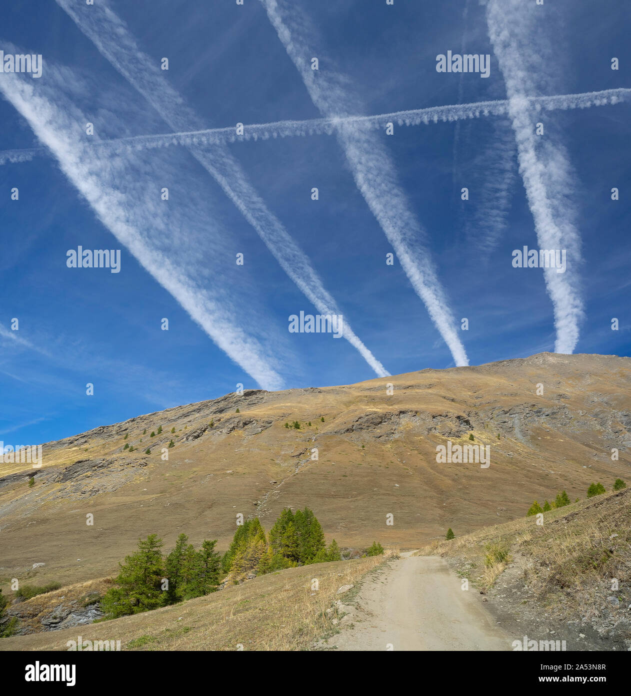 Kondensstreifen (Kondensstreifen) Überfahrt, Kondensstreifen von Jet im Himmel über eine unbefestigte Straße (Symbol der chaotischen Flugverkehr) Stockfoto Kondensstreifen (Kondensstreifen) Überfahrt, Kondensstreifen von Jet im Himmel über eine unbefestigte Straße (Symbol der chaotischen Flugverkehr) Stockfoto