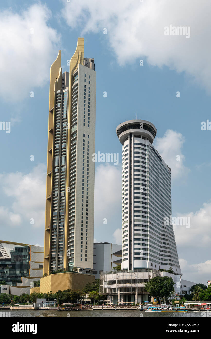 Die Stadt Bangkok, Thailand - 17. März 2019: Millennium Hilton weiße Gebäude und dem angrenzenden Gelbe Turm entlang den Fluss Chao Phraya mit Boot gegen den blauen Himmel Stockfoto