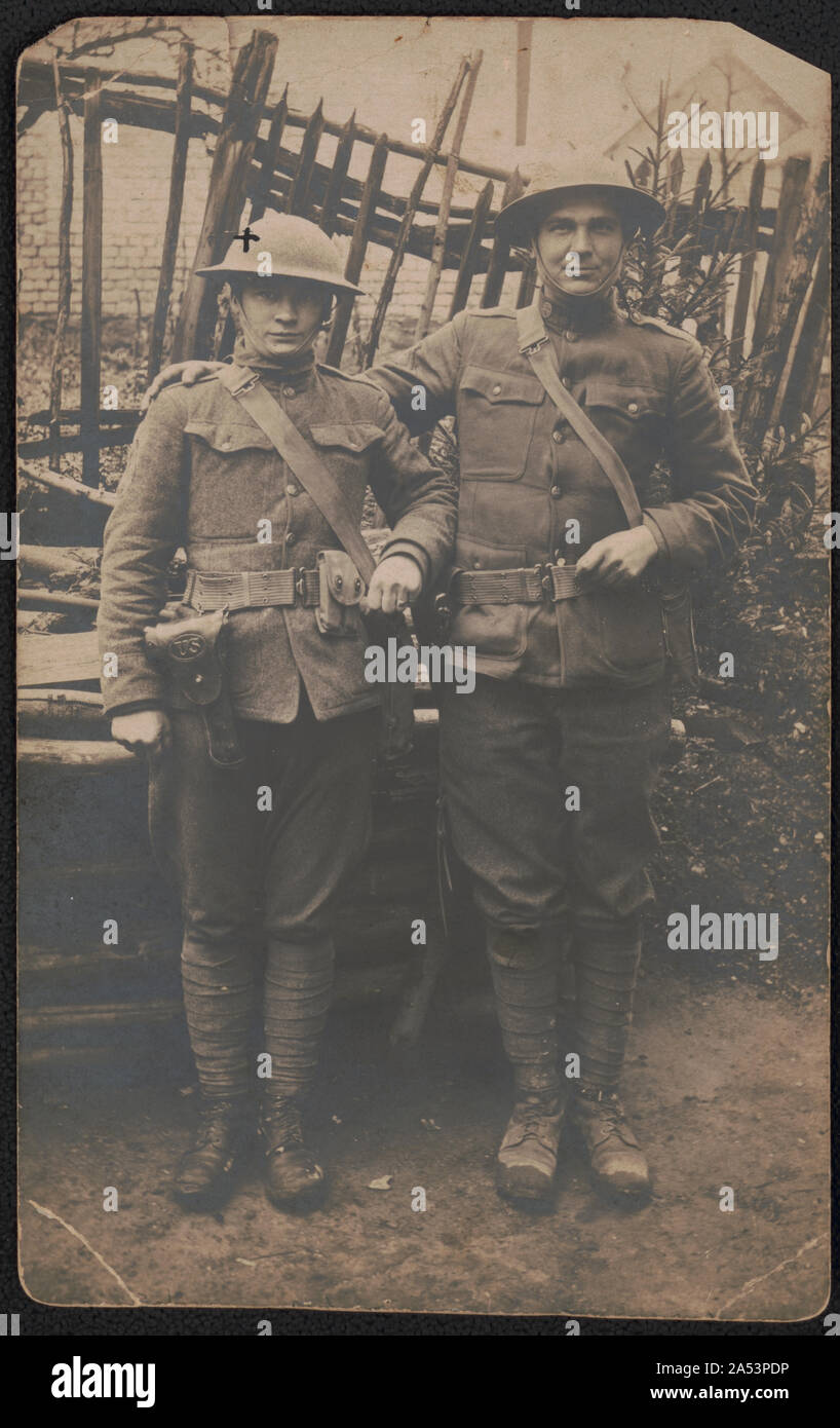 Zwei nicht identifizierte Soldaten, eines mit dem Namen Lester, in Uniformen und Helme mit Pistolen Stockfoto