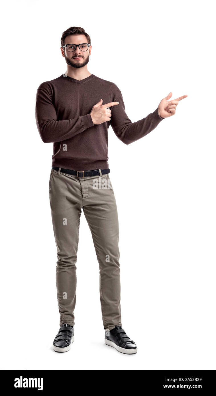 Ein bärtiger Mann im Smart Casual Kleidung sieht gerade und Punkte seitlich mit beiden Händen auf einem weißen Hintergrund. Stockfoto