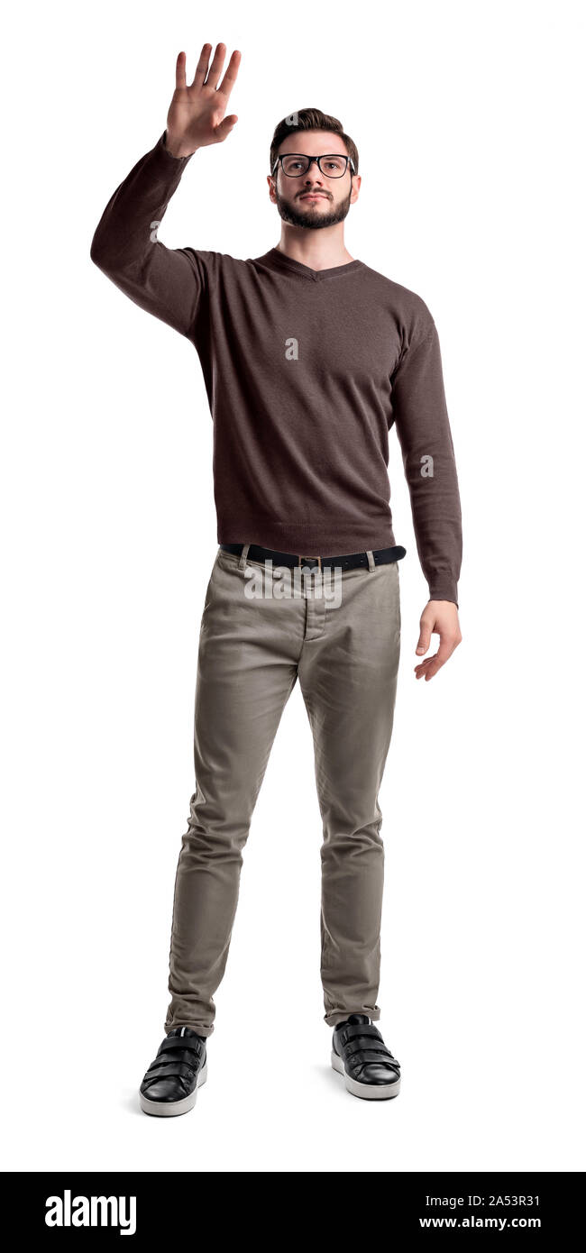 Ein junger bärtiger Mann im Cargo Hose hält seine Hand etwas zu tippen oder zu winken. Stockfoto