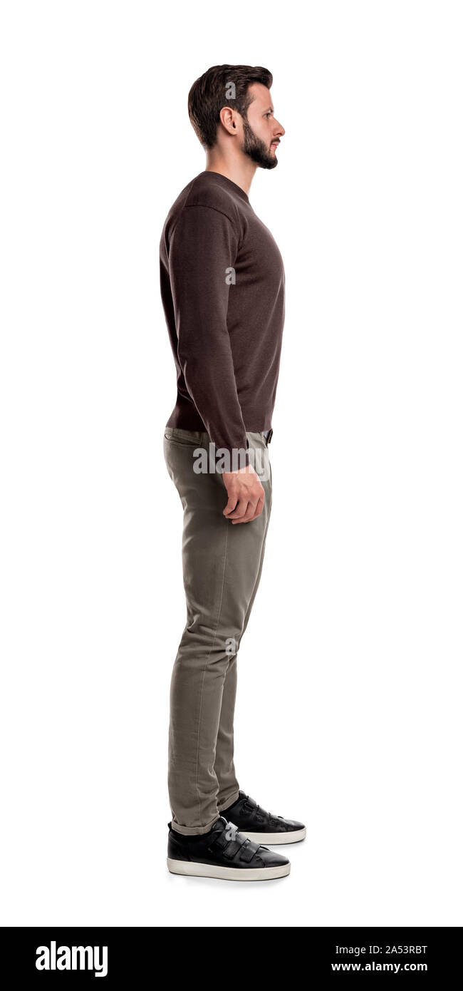 Ein bärtiger Mann in legere Kleidung steht immer noch mit den Armen hängend gerade auf seinen Seiten in der Seite. Stockfoto